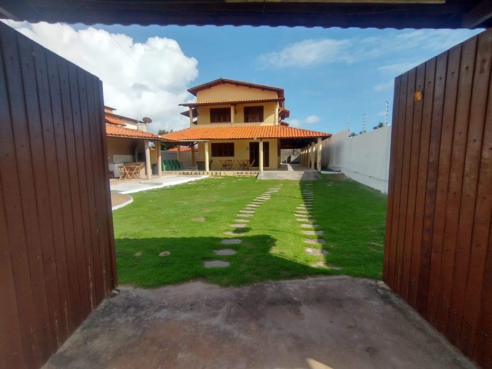 Entrada da casa com portão de madeira