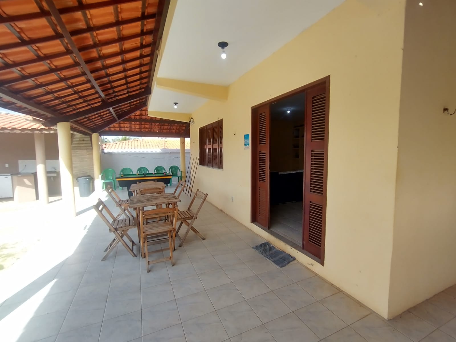 Varanda coberta com mesas e cadeiras